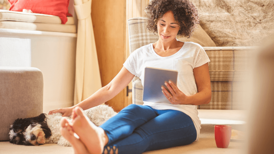 woman reading tablet near dog